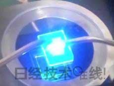   發(fā)光試驗中的LED元件。基板尺寸：1cm見方，元件尺寸：0.3mm見方，注入電流：約200mA，中心波長：450nm 